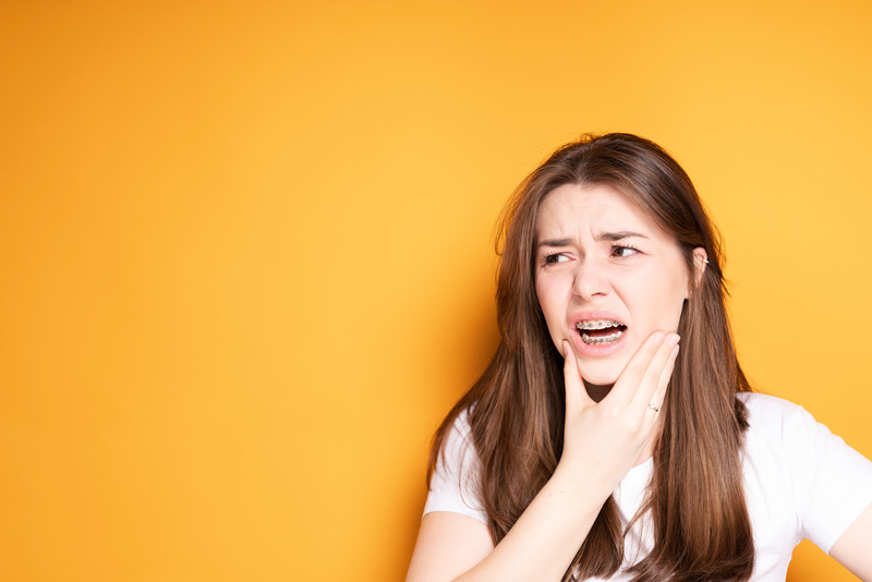 Patient holding their chin due to braces issues