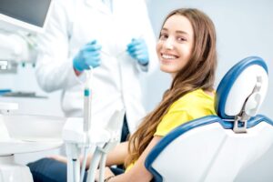 Smiling young woman in dental treatment chair